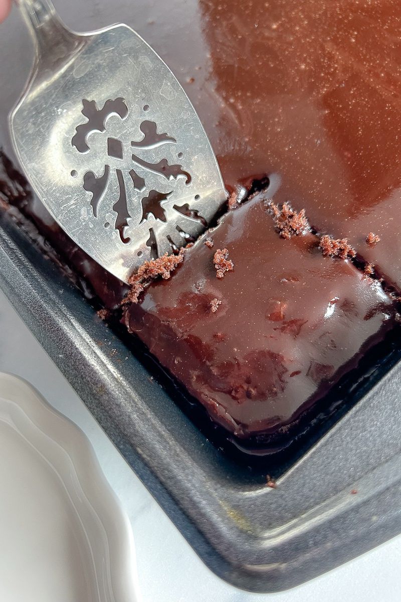 A slice of chocolate cake in a baking pan.