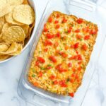 A platter or corn dip and a bowl of chips.