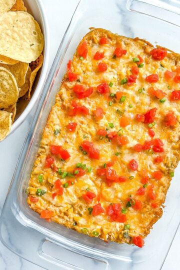 A platter or corn dip and a bowl of chips.