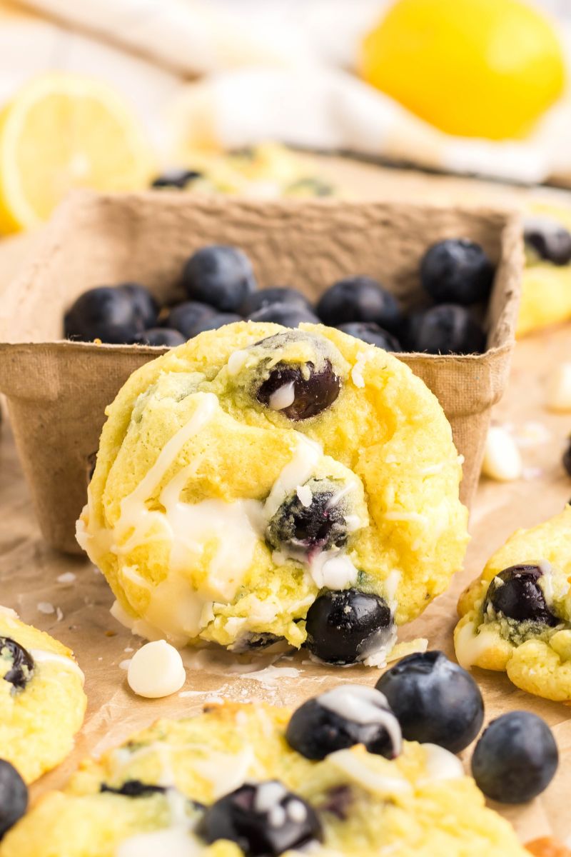A lemon cookie with a bowl of blueberries.