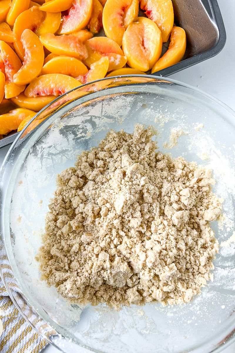 A pan of peaches and a bowl of mixed raw ingredients.