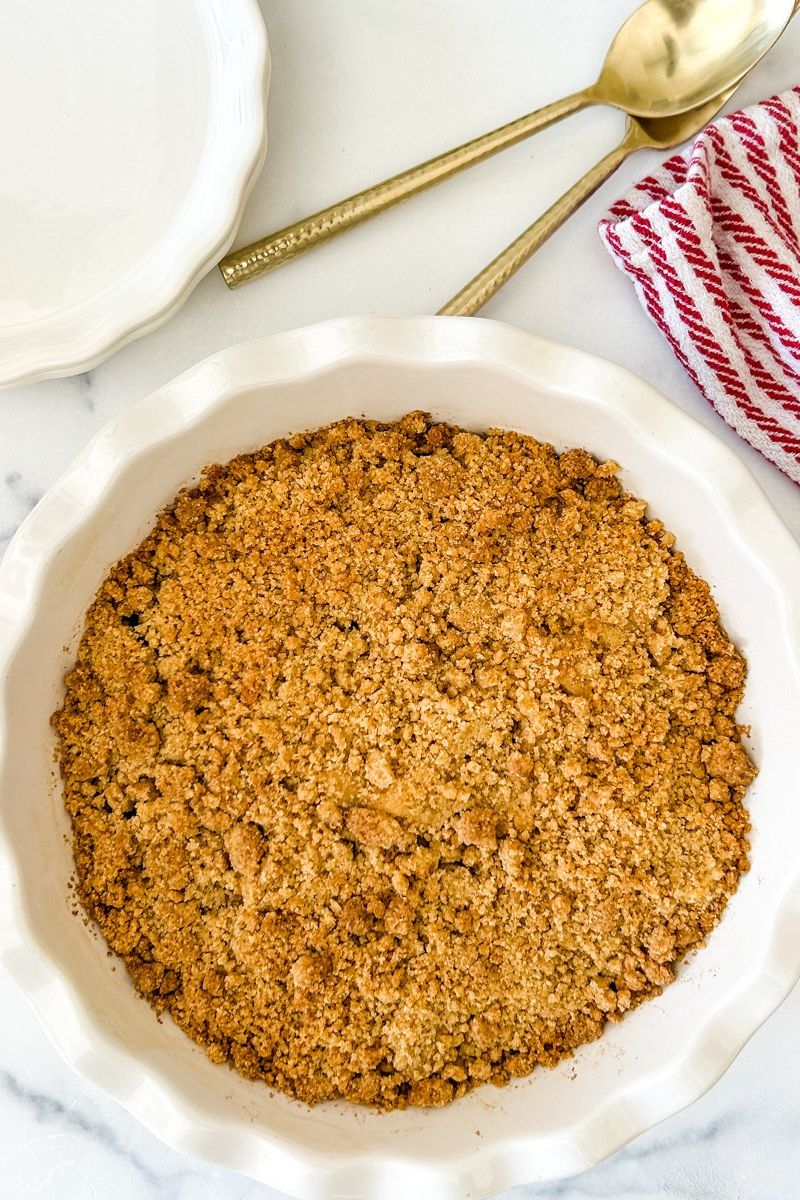 Baked pear crumble in a white pie pan.