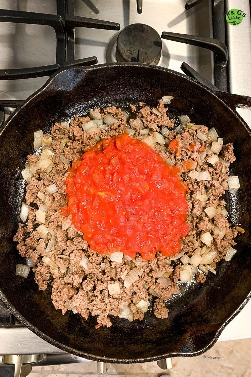 A skillet of meat mixture with red sauce.