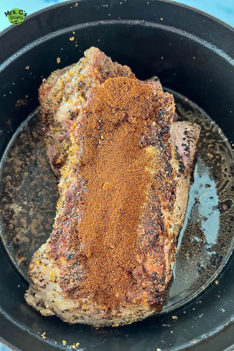 a pot of pork shoulder sprinkled with chili powder and cumin.