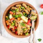 Zesty Italian Pasta Salad and silverwares on a wood bowl.
