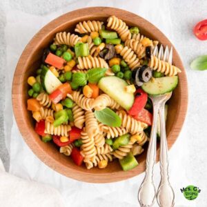 Zesty Italian Pasta Salad and silverwares on a wood bowl.